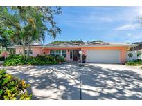 Charming single-story home with a spacious driveway, lush landscaping, and a welcoming front entrance at 3898 49Th S Ave, St Petersburg, FL 33711
