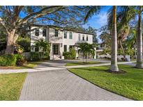 Elegant two-story home showcasing manicured landscaping, a paver driveway, and a modern architectural design at 503 W Davis Blvd, Tampa, FL 33606