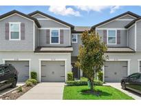 Charming townhome with gray siding, well-maintained landscaping, and a single-car garage at 5110 Sylvester Loop, Tampa, FL 33610