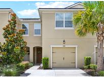 Charming two-story home with a well-maintained lawn, a beautiful tree, and an attached garage at 5808 Grand Sonata Ave, Lutz, FL 33558