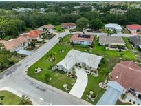 This aerial view captures a neighborhood with well-maintained lawns, mature trees, and diverse architectural styles at 602 Deep Lake Ln, Sun City Center, FL 33573