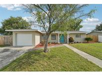Charming home featuring a well-manicured lawn and a pop of color with a vibrant turquoise front door at 6167 31St Ave, St Petersburg, FL 33710