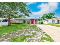 Charming single-story home featuring a well-maintained lawn and a vibrant red front door at 6237 50Th N Ave, St Petersburg, FL 33709