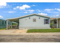 Charming single-story home featuring light blue siding, a covered carport, and a well-maintained lawn at 8443 Fantasia Park Way, Riverview, FL 33578