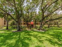 Beautiful exterior view of a multi-story building nestled among lush trees and green lawn, creating a serene environment at 3078 Eastland Blvd # 205, Clearwater, FL 33761