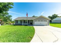 Charming single-story home with a well-manicured lawn, attached two-car garage, and a welcoming front porch at 37113 Waldo Dr, Dade City, FL 33525