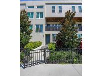 Three-story home boasts a sleek exterior with a charming wrought-iron fence and beautifully landscaped front yard at 4913 N Nebraska Ave # 5, Tampa, FL 33603