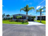 Exterior of a light blue home, lush landscaping, with two palm trees in the front yard at 5258 Wisteria Cir, New Port Richey, FL 34653