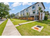 New construction exterior showcasing modern townhomes with manicured lawns and a sidewalk view at 532 W Plaza Pl # 3, Tampa, FL 33602