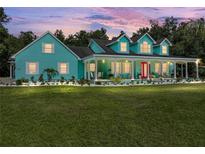 Charming two-story home with a large covered porch and beautifully landscaped front yard at 7427 20Th St, Zephyrhills, FL 33540
