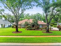 Charming single-story home with a well-manicured lawn and mature trees in a desirable neighborhood at 1015 Hastings Ct, Lutz, FL 33548