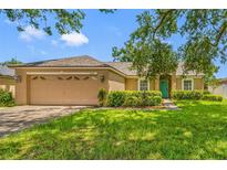 Charming one-story home with well-manicured lawn and a two-car garage at 14819 Redcliff Dr, Tampa, FL 33625