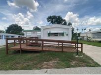 Charming white mobile home with a wooden ramp and awning in a well-maintained community at 1710 7Th Sw St # 82, Ruskin, FL 33570