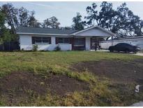 Cozy single story home featuring a covered porch and green lawn at 1922 Marvy Ave, Tampa, FL 33612