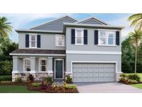 Charming two-story home with gray siding, stone accents, and a two-car garage at 2328 Stratten Dr, Zephyrhills, FL 33541