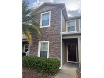Charming townhouse showcasing stone facade and verdant landscaping at 2411 Willimette Dr, Wesley Chapel, FL 33543