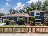 Charming two-story home featuring a well-manicured lawn, beautiful landscaping, and a classic fence at 2819 N Central Ave, Tampa, FL 33602