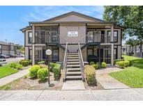 Exterior shot of the condo showing the stairs leading to the second floor units and well-maintained landscaping at 4014 Dream Oak Pl # 202, Tampa, FL 33613