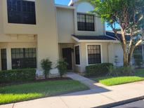 Charming townhouse exterior with well-maintained landscaping, shrubs and dark trimmed windows at 5100 Burchette Rd # 1304, Tampa, FL 33647