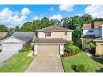 Charming two-story home with a well-manicured lawn and attached two-car garage on a beautiful sunny day at 6439 Gentle Ben Cir, Wesley Chapel, FL 33544