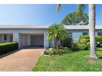 Charming home exterior with a well-maintained lawn, mature trees, and an attached garage for convenient parking at 8451 Candlewood Rd # 8451, Seminole, FL 33777