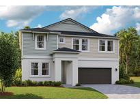 Charming two-story home featuring a manicured lawn and a gray and white exterior paint scheme at 10036 Surrey Rose Dr, San Antonio, FL 33576