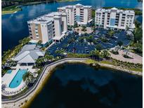 Stunning aerial view of condo buildings, pool, parking, and lakefront scenery, showcasing the community's amenities at 10520 Boardwalk Loop # 202, Bradenton, FL 34202