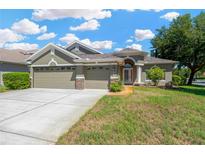Charming single-Gathering home featuring a three-car garage and a well-manicured lawn, perfect for suburban living at 11153 Biddeford Pl, New Port Richey, FL 34654