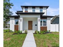 Modern two-story home featuring a manicured lawn, clean lines, and a contemporary front door and entrance at 1500 49Th N St, St Petersburg, FL 33710