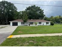 Charming single-story home with a well-manicured lawn and a large driveway at 17048 State Road 54, Lutz, FL 33558
