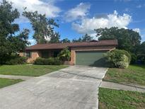 Charming single-story brick home with a well-maintained lawn and a two-car garage at 1813 Laurel Oak Dr, Valrico, FL 33596