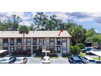 Exterior of a charming condo building with well-maintained landscaping, balconies, and convenient parking spaces at 2400 Winding Creek Blvd # Bldg18A210, Clearwater, FL 33761
