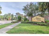 Arbor Chase entrance with brick columns, manicured landscaping, and a gated entrance to the community at 3603 Arbor Chase Dr, Palm Harbor, FL 34683