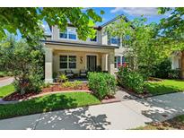 Charming two-story home with a welcoming front porch and well-manicured landscaping at 3833 Villamore Ln, Odessa, FL 33556
