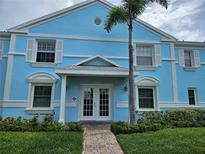 Charming light blue two-story condo with white trim, a brick pathway, and a well-manicured lawn at 4985 Cobia Se Dr # A, St Petersburg, FL 33705