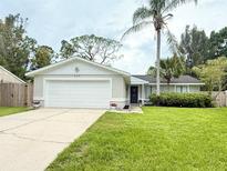 Charming single-story home featuring a well-manicured lawn and a two-car garage at 630 Timber Bay W Cir, Oldsmar, FL 34677