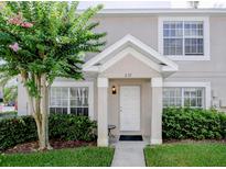 Charming townhome entrance with landscaped bushes, a flowering tree and a white door at 637 Kensington Lake Cir, Brandon, FL 33511