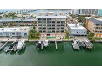 Stunning aerial view of waterfront condo with private boat slips and pool, set against a coastal backdrop at 706 Bayway Blvd # 503, Clearwater, FL 33767