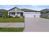 Charming single-story home featuring a three-car garage, well-maintained landscaping and a welcoming front porch at 8840 Mugnai St, Riverview, FL 33578