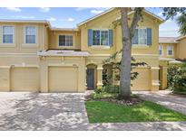 Charming townhome featuring colorful shutters, a well-manicured lawn and a paver driveway and walkway at 9206 River Rock Ln, Riverview, FL 33578