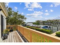 Enjoy the view of the marina from this cozy outdoor balcony with wood flooring and a decorative wood railing at 4304 Harbor House Dr, Tampa, FL 33615