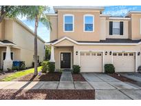 Charming townhome featuring a well-maintained lawn, a one-car garage, and neutral colored stucco at 1031 Andrew Aviles Cir, Tampa, FL 33619