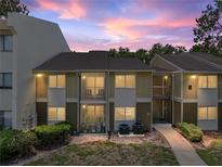 Charming condo building with two-story design and cozy patios overlooking the well-maintained landscaping at dusk at 13285 Arbor Pointe Cir # 202, Tampa, FL 33617