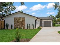 Charming single-story home featuring a stone accent wall, manicured lawn, and a well-maintained driveway at 1707 Solon Ave, Dunedin, FL 34698