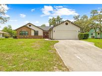 Charming single-story home with a well-manicured lawn and a two-car garage at 2141 Coachman Rd, Spring Hill, FL 34608