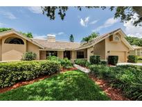 Charming single-story home with a well-manicured lawn, mature landscaping, and a tile roof at 2455 Anthony Ave, Clearwater, FL 33759