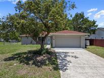 Charming single-story home with a two-car garage and a well-maintained front yard with mature trees at 3529 Orion Rd, Spring Hill, FL 34606