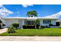 Charming single-story home with a well-manicured lawn, clean white exterior, and lush landscaping at 3605 100Th N Ter, Pinellas Park, FL 33782