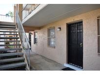 Exterior view of a condo entrance with a black security door, accessible by stairs leading to the second level at 4702 Michael Ct # 139, Tampa, FL 33614