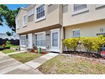 Charming townhome with manicured lawn, vibrant shrubs, and inviting front entrance at 6601 121St Ave # I, Largo, FL 33773